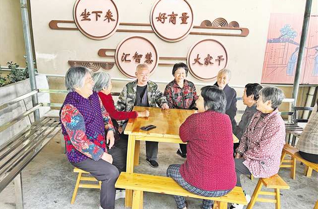 胡明清（左三）与小区业主交流。（受访者供图）